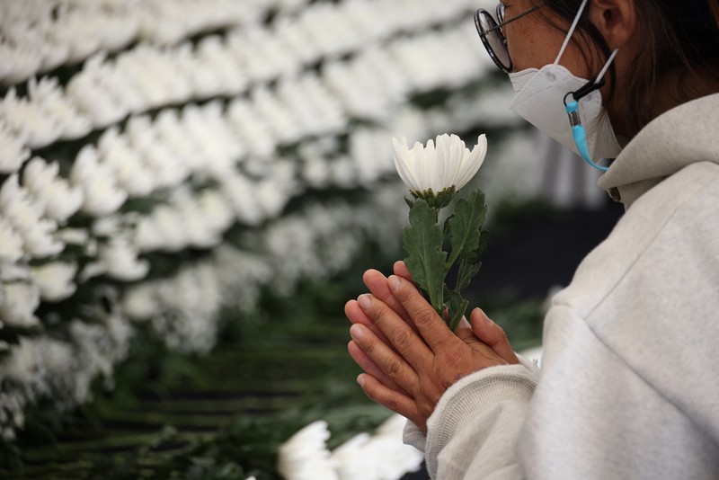 Seorang pria memberikan penghormatan di dekat lokasi penyerbuan yang terjadi selama perayaan Halloween, di Seoul, Korea Selatan, 31 Oktober 2022. (REUTERS/KIM HONG-JI)