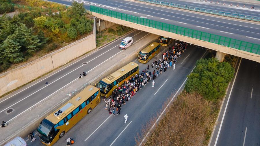 ZHENGZHOU, CHINA - OCTOBER 30: Foxconn employees take shuttle buses to head home on October 30, 2022 in Zhengzhou, Henan Province of China. Shuttle buses have been arranged by local authorities to facilitate the return trips of Foxconn factory workers to their hometowns after COVID-19 infections were reported in the city Zhengzhou. (VCG/VCG via Getty Images)