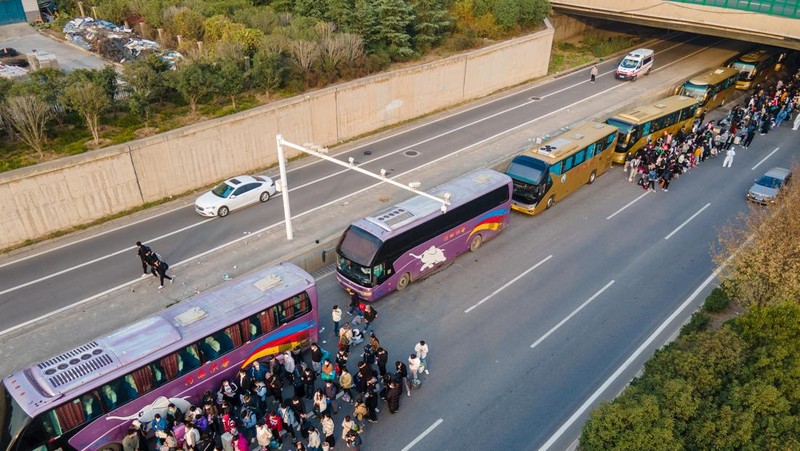 ZHENGZHOU, CHINA - OCTOBER 30: Foxconn employees take shuttle buses to head home on October 30, 2022 in Zhengzhou, Henan Province of China. Shuttle buses have been arranged by local authorities to facilitate the return trips of Foxconn factory workers to their hometowns after COVID-19 infections were reported in the city Zhengzhou. (VCG/VCG via Getty Images)