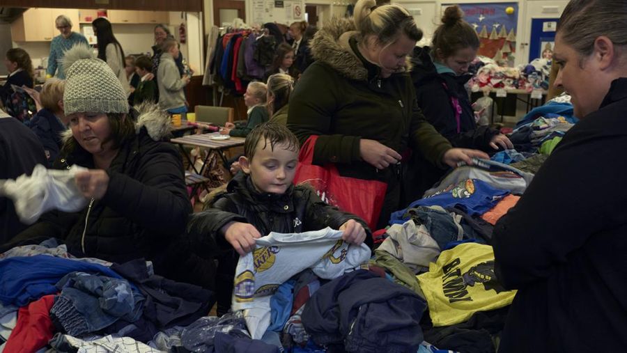 CAMBORNE, ENGLAND - NOVEMBER 01: Members of the public look through free clothes at a warm bank provided by Camborne Parish Church on November 1, 2022 in Camborne, United Kingdom. With the cost of living crisis and increase in energy bills affecting households across the UK this winter, many councils are opening safe, heated spaces where people who can't afford to heat their homes can spend time. These spaces are known as warmth or warm banks and charities say that they should only be a short-term fix to the issues facing people and not the long-term solution as foodbanks have become. (Alex McBride/Getty Images)