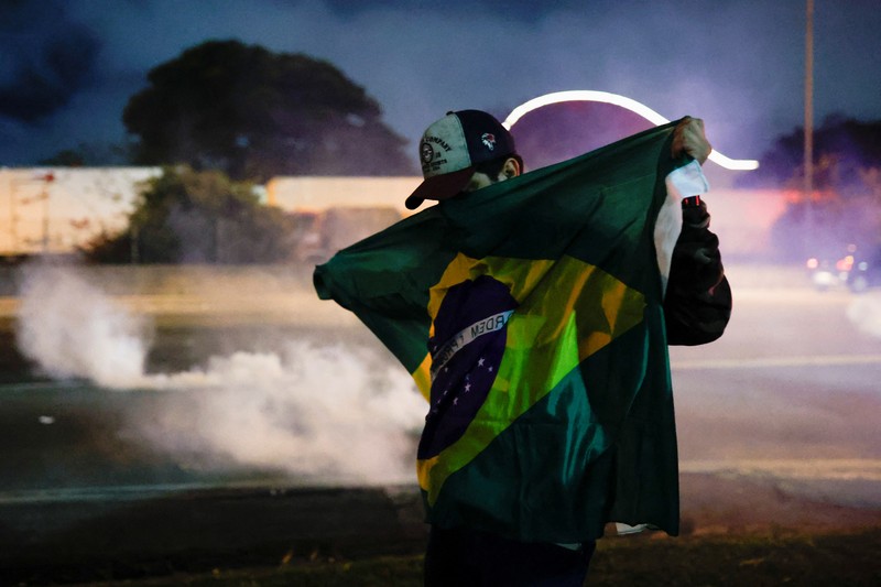 Seorang demonstran menendang kembali tabung gas air mata selama protes atas kekalahan Presiden Brasil Jair Bolsonaro dalam pemilihan presiden putaran kedua di Barueri, Brasil 1 November 2022. (REUTERS/Amanda Perobelli)