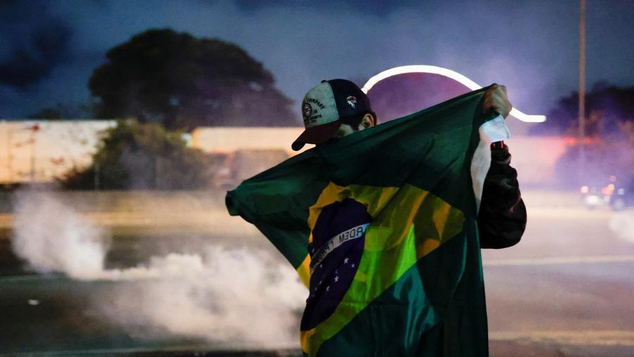 Seorang demonstran menendang kembali tabung gas air mata selama protes atas kekalahan Presiden Brasil Jair Bolsonaro dalam pemilihan presiden putaran kedua di Barueri, Brasil 1 November 2022. (REUTERS/Amanda Perobelli)