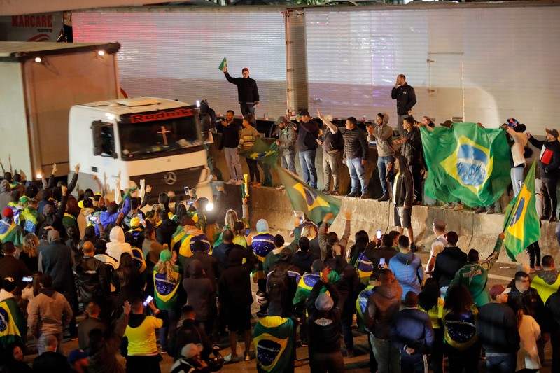 Seorang demonstran menendang kembali tabung gas air mata selama protes atas kekalahan Presiden Brasil Jair Bolsonaro dalam pemilihan presiden putaran kedua di Barueri, Brasil 1 November 2022. (REUTERS/Amanda Perobelli)
