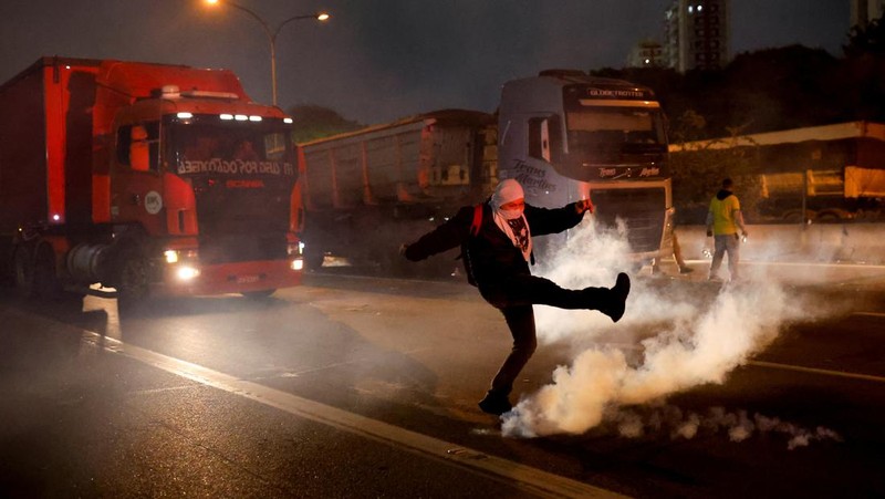 Seorang demonstran menendang kembali tabung gas air mata selama protes atas kekalahan Presiden Brasil Jair Bolsonaro dalam pemilihan presiden putaran kedua di Barueri, Brasil 1 November 2022. (REUTERS/Amanda Perobelli)
