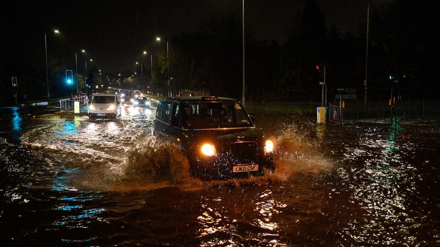 LONDON, ENGLAND - NOVEMBER 02: A car negotiates a flooded section of the A1 road on November 02, 2022 in London, England. Torrential rain and flash flooding hit the region late on Wednesday evening, causing traffic jams as cars became stuck in the standing water. (Photo by Leon Neal/Getty Images)