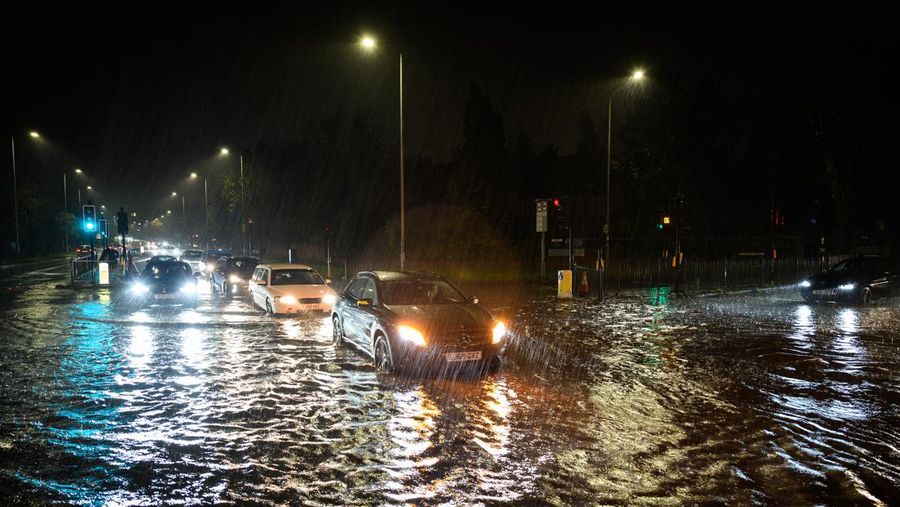 LONDON, ENGLAND - NOVEMBER 02: A car negotiates a flooded section of the A1 road on November 02, 2022 in London, England. Torrential rain and flash flooding hit the region late on Wednesday evening, causing traffic jams as cars became stuck in the standing water. (Photo by Leon Neal/Getty Images)