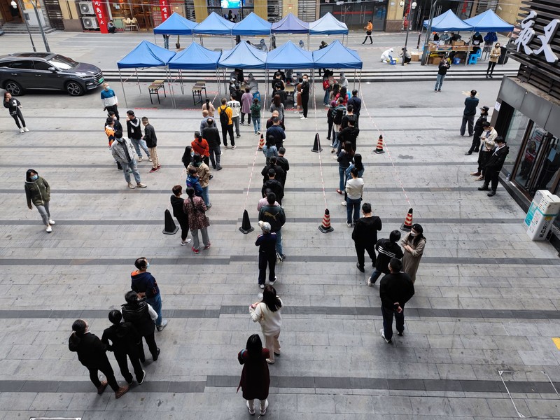 Virus Outbreak China A woman gets her routine COVID-19 throat swab at a coronavirus testing site setup along a pedestrian walkway in Beijing, Thursday, Nov. 3, 2022. The ruling Communist Party is enforcing a