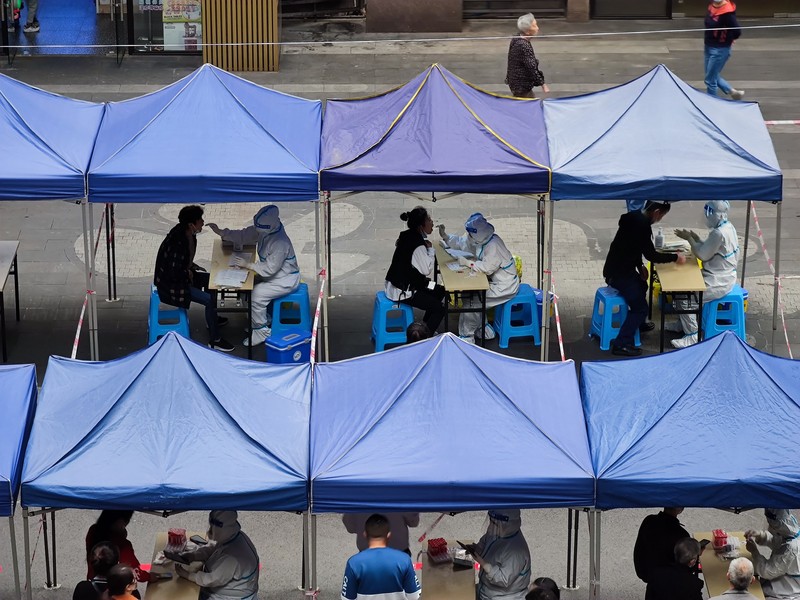 Virus Outbreak China A woman gets her routine COVID-19 throat swab at a coronavirus testing site setup along a pedestrian walkway in Beijing, Thursday, Nov. 3, 2022. The ruling Communist Party is enforcing a