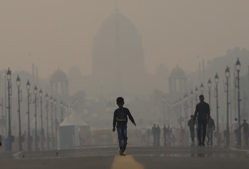 NEW DELHI, INDIA - NOVEMBER 03: A boy make their way past the presidential palace amid smoggy conditions in New Delhi on November 03, 2022. Air Quality Index between 401 and 500 is considered to be 'severe'. According to the CPCB, AQI in the severe category affects healthy people and seriously impacts those with existing diseases. (Amarjeet Kumar Singh/Anadolu Agency via Getty Images)