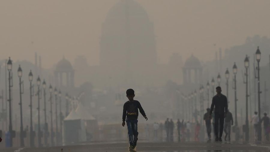 NEW DELHI, INDIA - NOVEMBER 03: A boy make their way past the presidential palace amid smoggy conditions in New Delhi on November 03, 2022. Air Quality Index between 401 and 500 is considered to be 'severe'. According to the CPCB, AQI in the severe category affects healthy people and seriously impacts those with existing diseases. (Amarjeet Kumar Singh/Anadolu Agency via Getty Images)