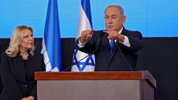 Mantan perdana menteri Israel dan pemimpin partai Likud Benjamin Netanyahu berbicara kepada para pendukung, diapit oleh istrinya Sara, di markas kampanye di Yerusalem pada awal 2 November 2022. (AFP/RONALDO SCHEMIDT) Mantan perdana menteri Israel dan pemimpin partai Likud Benjamin Netanyahu berbicara kepada para pendukung, diapit oleh istrinya Sara, di markas kampanye di Yerusalem pada awal 2 November 2022. (AFP/RONALDO SCHEMIDT)