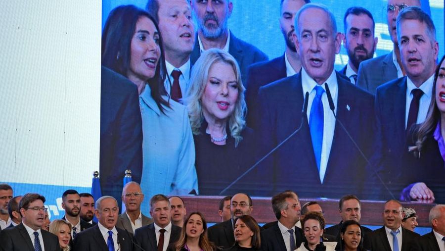 Mantan perdana menteri Israel dan pemimpin partai Likud Benjamin Netanyahu dan anggota partai menyanyikan lagu kebangsaan saat mereka berbicara kepada para pendukung di markas kampanye di Yerusalem pada 2 November 2022. (AFP/MENAHEM KAHANA)