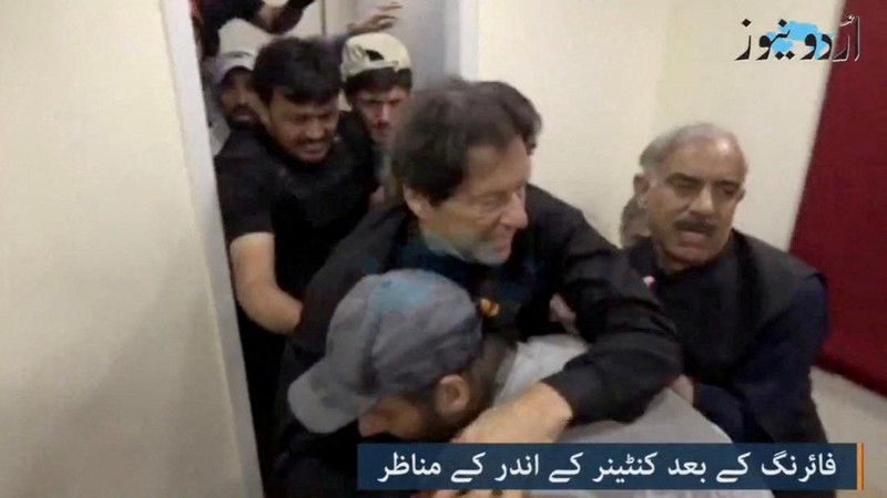 Seorang anak laki-laki menonton saluran televisi yang menayangkan berita tentang mantan perdana menteri Pakistan Imran Khan, di Islamabad pada 3 November 2022. (AFP via Getty Images/FAROOQ NAEEM)