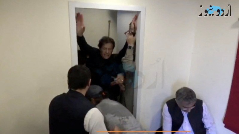 Seorang anak laki-laki menonton saluran televisi yang menayangkan berita tentang mantan perdana menteri Pakistan Imran Khan, di Islamabad pada 3 November 2022. (AFP via Getty Images/FAROOQ NAEEM)