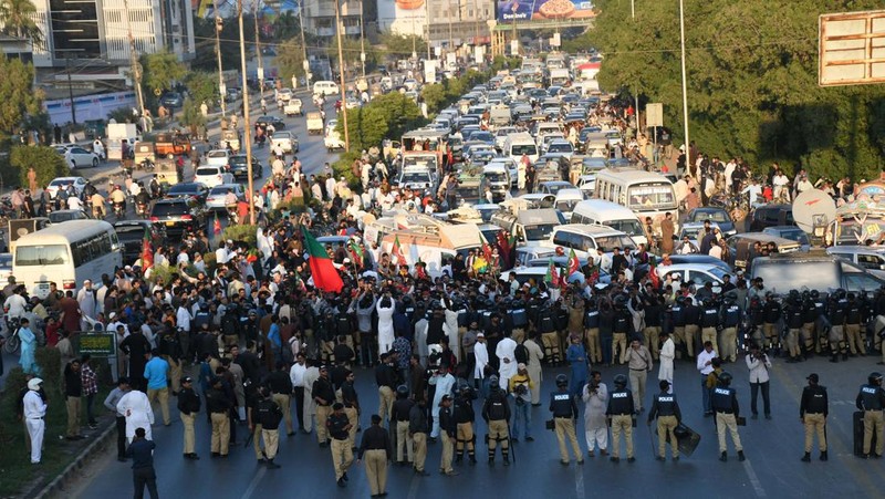Seorang petugas polisi menembakkan gas air mata untuk membubarkan orang-orang selama protes mengutuk insiden penembakan pada long march yang diadakan oleh mantan Perdana Menteri Pakistan Imran Khan di Wazirabad, di Rawalpindi, Pakistan 4 November 2022. (REUTERS/STRINGER)