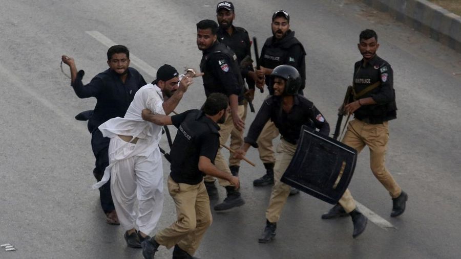 Seorang petugas polisi menembakkan gas air mata untuk membubarkan orang-orang selama protes mengutuk insiden penembakan pada long march yang diadakan oleh mantan Perdana Menteri Pakistan Imran Khan di Wazirabad, di Rawalpindi, Pakistan 4 November 2022. (REUTERS/STRINGER)