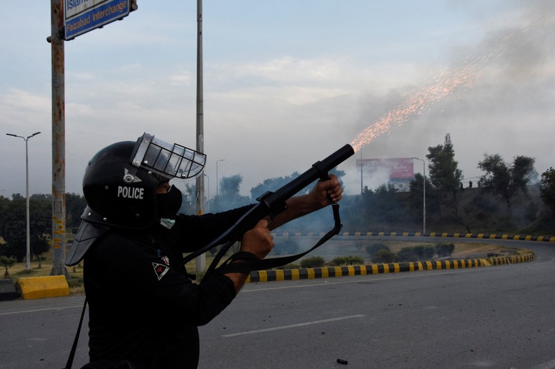 Seorang petugas polisi menembakkan gas air mata untuk membubarkan orang-orang selama protes mengutuk insiden penembakan pada long march yang diadakan oleh mantan Perdana Menteri Pakistan Imran Khan di Wazirabad, di Rawalpindi, Pakistan 4 November 2022. (REUTERS/STRINGER) Seorang petugas polisi menembakkan gas air mata untuk membubarkan orang-orang selama protes mengutuk insiden penembakan pada long march yang diadakan oleh mantan Perdana Menteri Pakistan Imran Khan di Wazirabad, di Rawalpindi, Pakistan 4 November 2022. (REUTERS/STRINGER)
