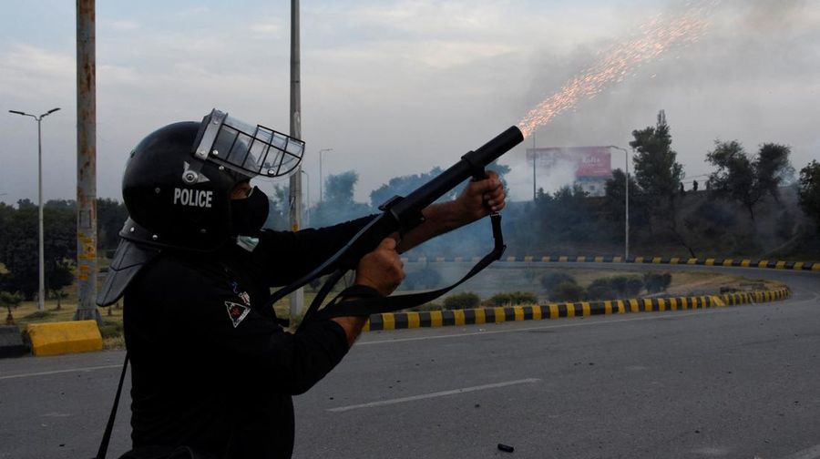 Seorang petugas polisi menembakkan gas air mata untuk membubarkan orang-orang selama protes mengutuk insiden penembakan pada long march yang diadakan oleh mantan Perdana Menteri Pakistan Imran Khan di Wazirabad, di Rawalpindi, Pakistan 4 November 2022. (REUTERS/STRINGER)