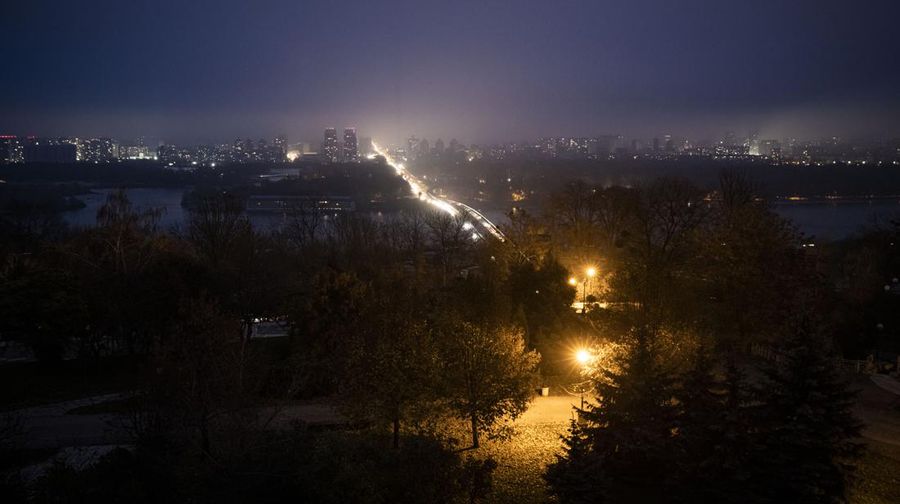 KYIV, UKRAINE - NOVEMBER 05: Cars cross the Metro Bridge and drive on the left bank between dark buildings at dusk on November 05, 2022 in Kyiv, Ukraine. Electricity and heating outages across Ukraine caused by missile and drone strikes to energy infrastructure have added urgency preparations for winter. (Photo by Ed Ram/Getty Images)