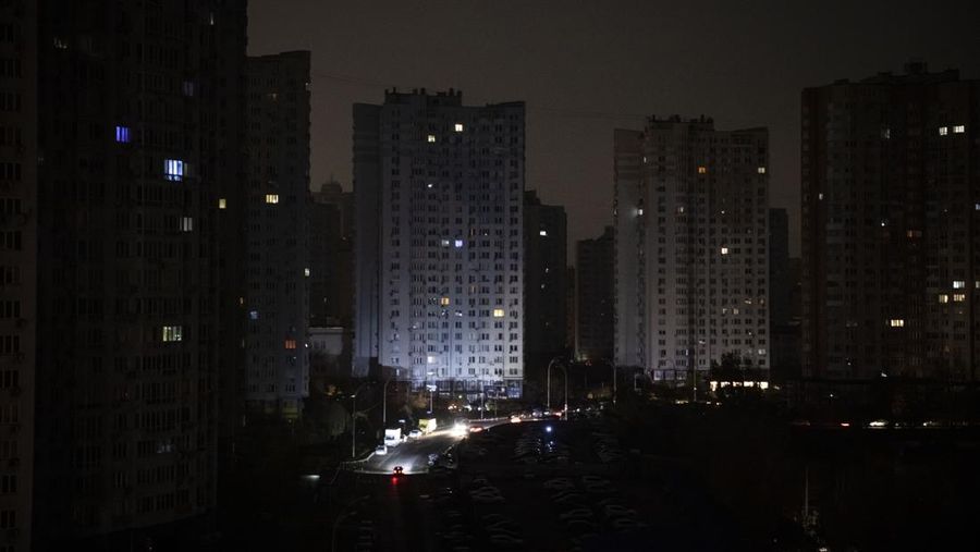 KYIV, UKRAINE - NOVEMBER 06: Apartment blocks stand in near total darkness during a scheduled power cut on the left bank of the River Dnipro November 06, 2022 in Kyiv, Ukraine. Electricity and heating outages across Ukraine caused by missile and drone strikes to energy infrastructure have added urgency preparations for winter. (Photo by Ed Ram/Getty Images)