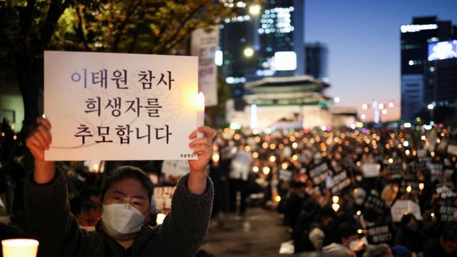 Presiden Korea Selatan Yoon Suk-yeol memegang bunga untuk ditempatkan sebagai penghormatan kepada para korban saat ia mengunjungi lokasi kejadian peristiwa Itaewon saat perayaan Halloween, di Seoul, Korea Selatan, 1 November 2022. (REUTERS/Kim Hong-Ji)