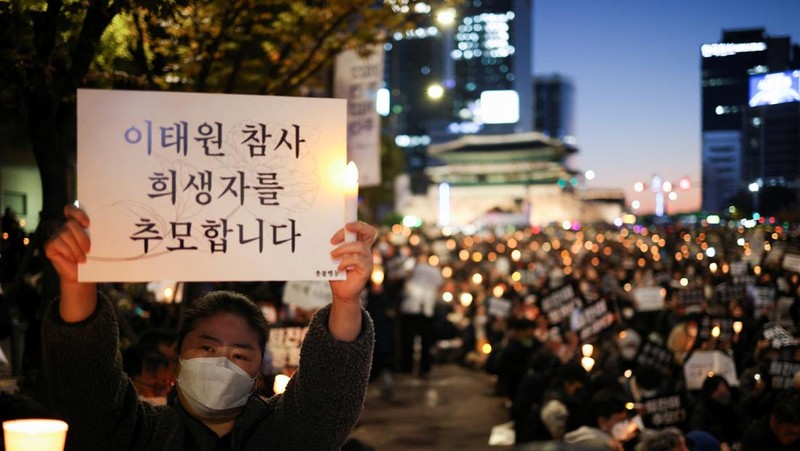Presiden Korea Selatan Yoon Suk-yeol memegang bunga untuk ditempatkan sebagai penghormatan kepada para korban saat ia mengunjungi lokasi kejadian peristiwa Itaewon saat perayaan Halloween, di Seoul, Korea Selatan, 1 November 2022. (REUTERS/Kim Hong-Ji)