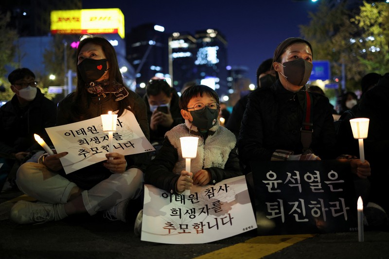 Presiden Korea Selatan Yoon Suk-yeol memegang bunga untuk ditempatkan sebagai penghormatan kepada para korban saat ia mengunjungi lokasi kejadian peristiwa Itaewon saat perayaan Halloween, di Seoul, Korea Selatan, 1 November 2022. (REUTERS/Kim Hong-Ji)