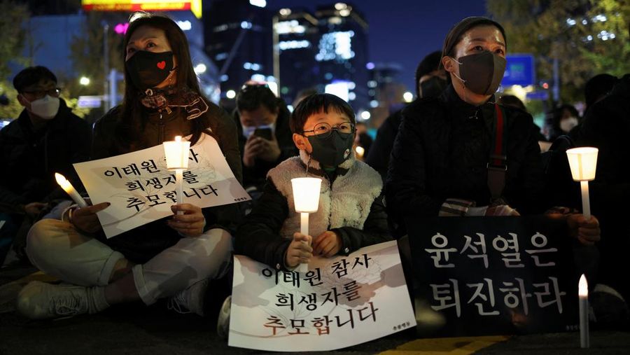 Presiden Korea Selatan Yoon Suk-yeol memegang bunga untuk ditempatkan sebagai penghormatan kepada para korban saat ia mengunjungi lokasi kejadian peristiwa Itaewon saat perayaan Halloween, di Seoul, Korea Selatan, 1 November 2022. (REUTERS/Kim Hong-Ji)
