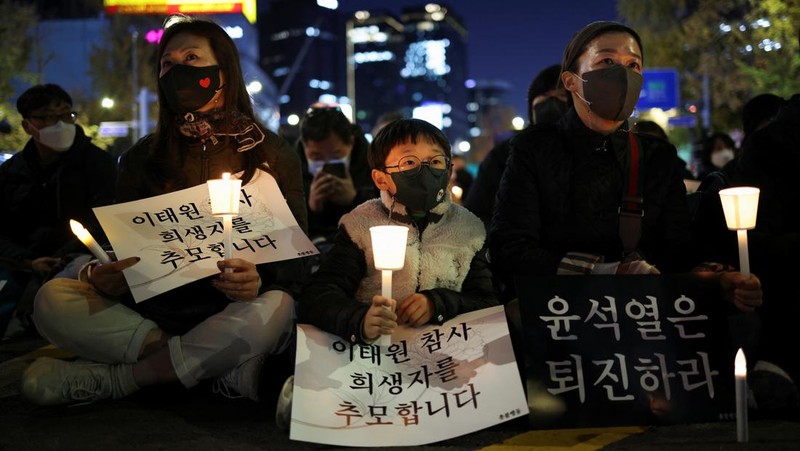 Presiden Korea Selatan Yoon Suk-yeol memegang bunga untuk ditempatkan sebagai penghormatan kepada para korban saat ia mengunjungi lokasi kejadian peristiwa Itaewon saat perayaan Halloween, di Seoul, Korea Selatan, 1 November 2022. (REUTERS/Kim Hong-Ji)