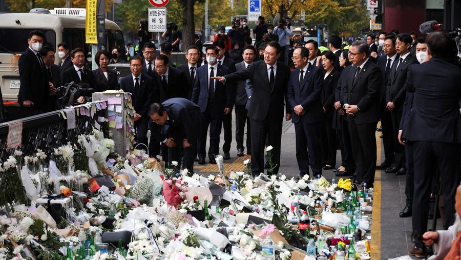 Presiden Korea Selatan Yoon Suk-yeol memegang bunga untuk ditempatkan sebagai penghormatan kepada para korban saat ia mengunjungi lokasi kejadian peristiwa Itaewon saat perayaan Halloween, di Seoul, Korea Selatan, 1 November 2022. (REUTERS/Kim Hong-Ji)