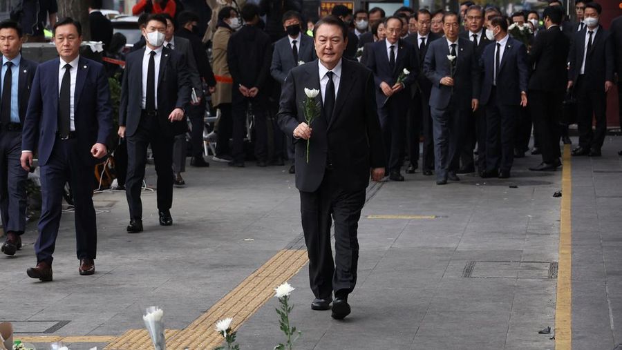Presiden Korea Selatan Yoon Suk-yeol memegang bunga untuk ditempatkan sebagai penghormatan kepada para korban saat ia mengunjungi lokasi kejadian peristiwa Itaewon saat perayaan Halloween, di Seoul, Korea Selatan, 1 November 2022. (REUTERS/Kim Hong-Ji)