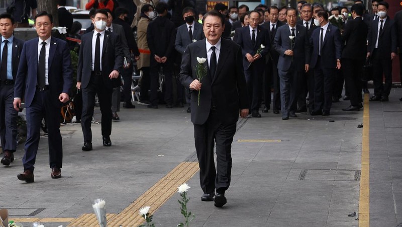 Presiden Korea Selatan Yoon Suk-yeol memegang bunga untuk ditempatkan sebagai penghormatan kepada para korban saat ia mengunjungi lokasi kejadian peristiwa Itaewon saat perayaan Halloween, di Seoul, Korea Selatan, 1 November 2022. (REUTERS/Kim Hong-Ji)