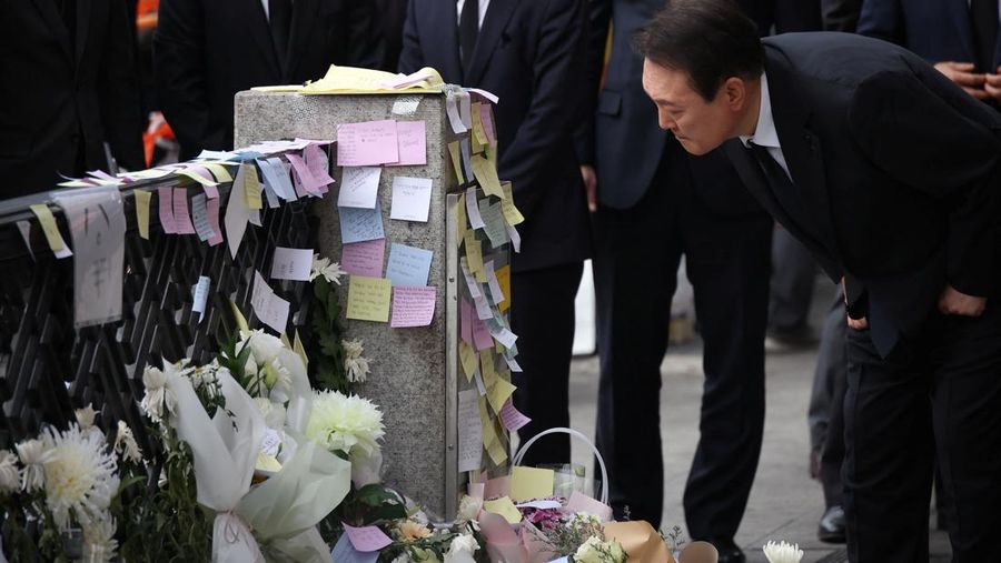 Presiden Korea Selatan Yoon Suk-yeol memegang bunga untuk ditempatkan sebagai penghormatan kepada para korban saat ia mengunjungi lokasi kejadian peristiwa Itaewon saat perayaan Halloween, di Seoul, Korea Selatan, 1 November 2022. (REUTERS/Kim Hong-Ji)