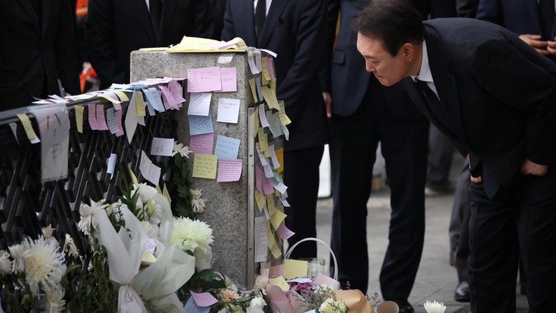 Presiden Korea Selatan Yoon Suk-yeol memegang bunga untuk ditempatkan sebagai penghormatan kepada para korban saat ia mengunjungi lokasi kejadian peristiwa Itaewon saat perayaan Halloween, di Seoul, Korea Selatan, 1 November 2022. (REUTERS/Kim Hong-Ji)