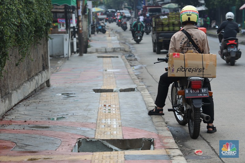 Warga keluhkan trotoar berlubang pasca pengerjaan pedestrian karena terhalang dan membahayakan pejalan kaki saat melintas di Jalan Pahlawan Rempoa, Tangerang Selatan, Senin (7/11/2022). (CNBC Indonesia/ Muhammad Sabki)