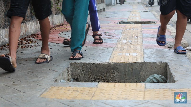 Warga keluhkan trotoar berlubang pasca pengerjaan pedestrian di Jalan Pahlawan Rempoa, Tangerang Selatan, Senin (7/11/2022). Warga keluhkan trotoar berlubang pasca pengerjaan pedestrian karena terhalang dan membahayakan pejalan kaki saat melintas di Jalan Pahlawan Rempoa, Tangerang Selatan, Senin (7/11/2022). (CNBC Indonesia/ Muhammad Sabki)