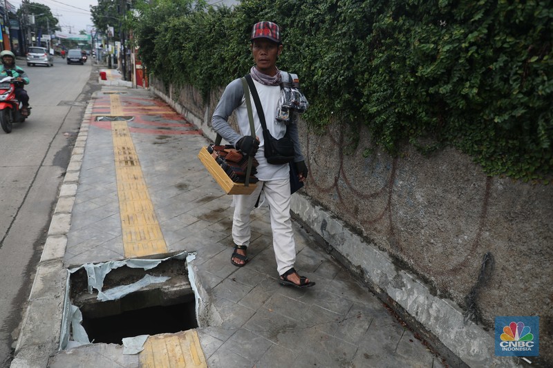 Warga keluhkan trotoar berlubang pasca pengerjaan pedestrian karena terhalang dan membahayakan pejalan kaki saat melintas di Jalan Pahlawan Rempoa, Tangerang Selatan, Senin (7/11/2022). (CNBC Indonesia/ Muhammad Sabki)