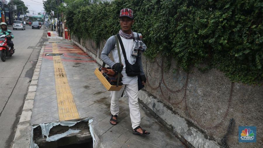 Warga keluhkan trotoar berlubang pasca pengerjaan pedestrian karena terhalang dan membahayakan pejalan kaki saat melintas di Jalan Pahlawan Rempoa, Tangerang Selatan, Senin (7/11/2022). (CNBC Indonesia/ Muhammad Sabki)