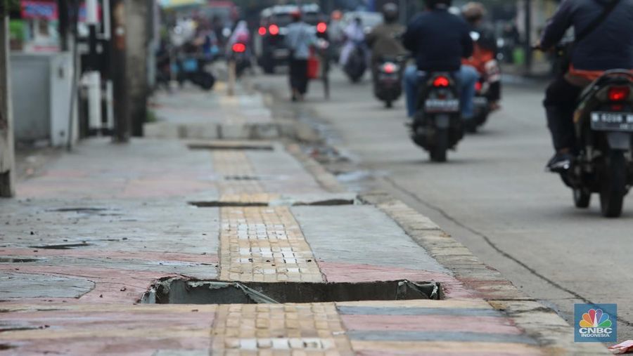 Warga keluhkan trotoar berlubang pasca pengerjaan pedestrian karena terhalang dan membahayakan pejalan kaki saat melintas di Jalan Pahlawan Rempoa, Tangerang Selatan, Senin (7/11/2022). (CNBC Indonesia/ Muhammad Sabki)