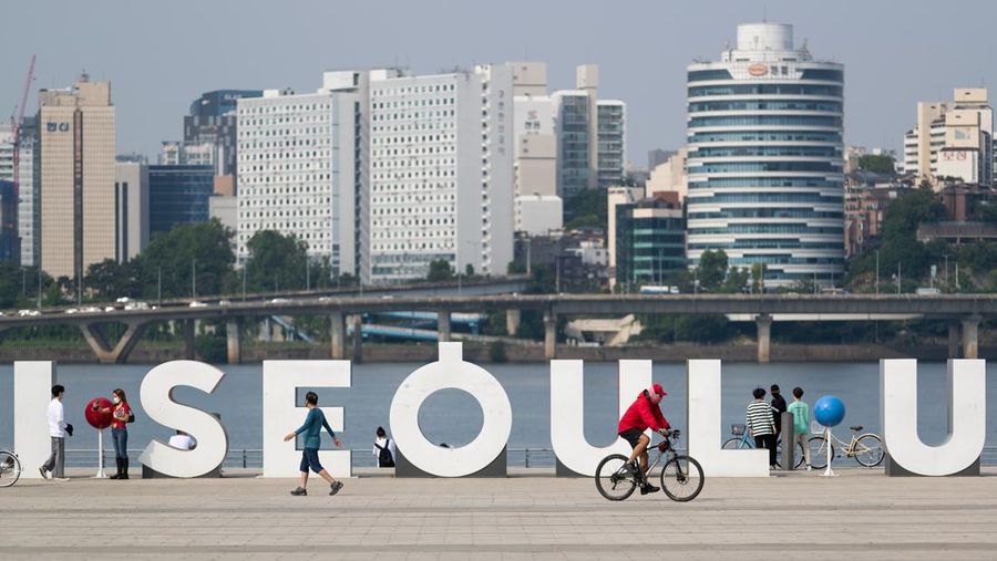 Orang-orang memakai masker wajah sebagai tindakan pencegahan penyebaran COVID-19 di Yeouido Hangang River Park di Seoul, Korea Selatan. (Chris Jung/NurPhoto via Getty Images)