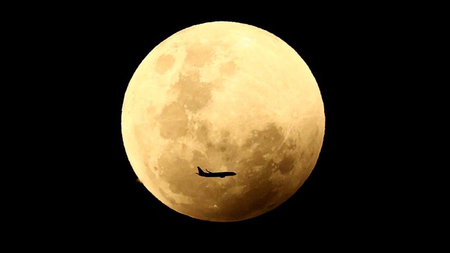 Sebuah pesawat terbang di depan bulan purnama menjelang gerhana bulan total dan bulan darah pada 08 November 2022 di Sydney, Australia. Warga Australia akan mengalami gerhana bulan total pertama yang terlihat tahun ini pada hari Selasa, ABC melaporkan, dengan gerhana juga terlihat dari Selandia Baru.