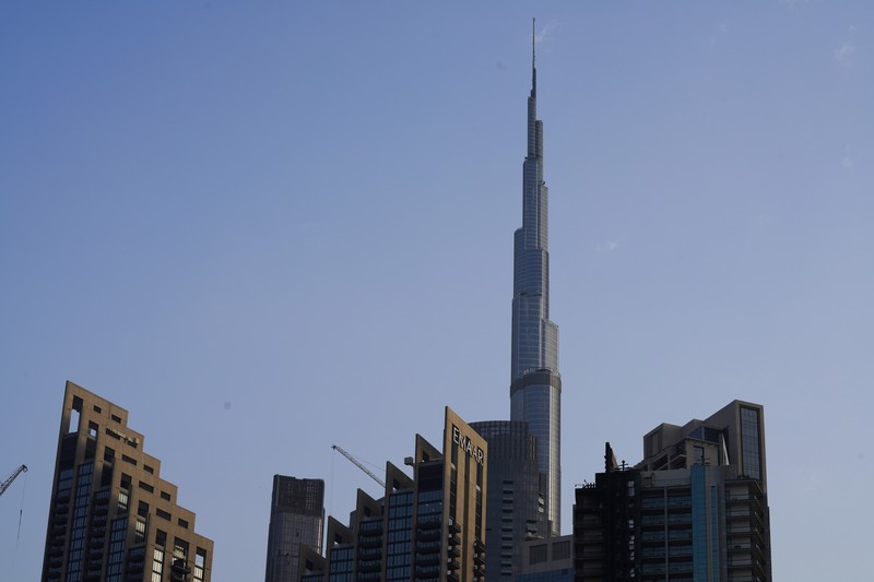8 Boulevard Walk bertingkat tinggi, kanan bawah, menunjukkan kerusakan akibat kebakaran dengan Burj Khalifa, gedung tertinggi di dunia, terlihat di belakangnya di Dubai, Uni Emirat Arab, Senin, 7 November 2022. The high-rise 8 Boulevard Walk, bottom right, shows fire damage with the Burj Khalifa, the world's tallest building, seen behind it in Dubai, United Arab Emirates, Monday, Nov. 7, 2022. A fire broke out early Monday morning at a 35-story high-rise building in Dubai near the Burj Khalifa, the world's tallest building. (AP Photo/Jon Gambrell)