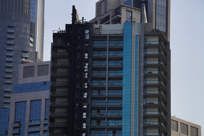 The high-rise 8 Boulevard Walk, bottom right, shows fire damage with the Burj Khalifa, the world's tallest building, seen behind it in Dubai, United Arab Emirates, Monday, Nov. 7, 2022. A fire broke out early Monday morning at a 35-story high-rise building in Dubai near the Burj Khalifa, the world's tallest building. (AP Photo/Jon Gambrell)