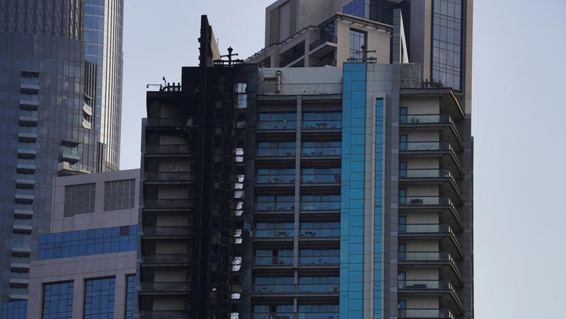 The high-rise 8 Boulevard Walk, bottom right, shows fire damage with the Burj Khalifa, the world's tallest building, seen behind it in Dubai, United Arab Emirates, Monday, Nov. 7, 2022. A fire broke out early Monday morning at a 35-story high-rise building in Dubai near the Burj Khalifa, the world's tallest building. (AP Photo/Jon Gambrell)