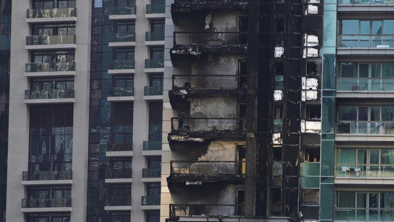 The high-rise 8 Boulevard Walk, bottom right, shows fire damage with the Burj Khalifa, the world's tallest building, seen behind it in Dubai, United Arab Emirates, Monday, Nov. 7, 2022. A fire broke out early Monday morning at a 35-story high-rise building in Dubai near the Burj Khalifa, the world's tallest building. (AP Photo/Jon Gambrell)