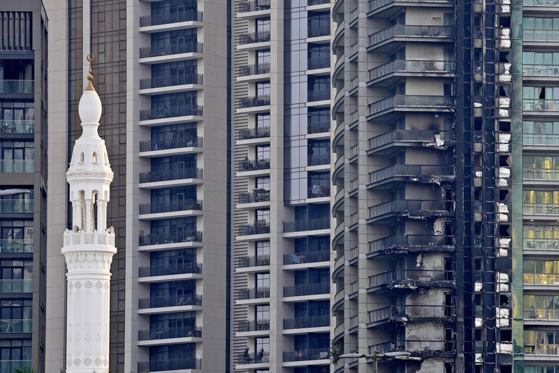 8 Boulevard Walk bertingkat tinggi, kanan bawah, menunjukkan kerusakan akibat kebakaran dengan Burj Khalifa, gedung tertinggi di dunia, terlihat di belakangnya di Dubai, Uni Emirat Arab, Senin, 7 November 2022. The high-rise 8 Boulevard Walk, bottom right, shows fire damage with the Burj Khalifa, the world's tallest building, seen behind it in Dubai, United Arab Emirates, Monday, Nov. 7, 2022. A fire broke out early Monday morning at a 35-story high-rise building in Dubai near the Burj Khalifa, the world's tallest building. (AP Photo/Jon Gambrell)
