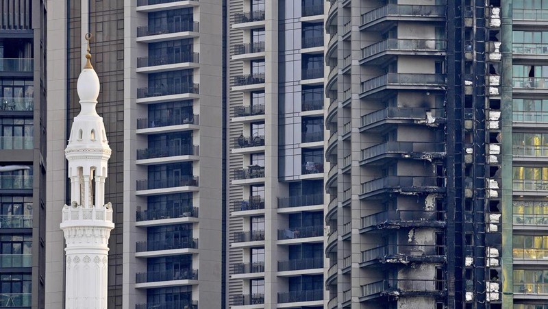 The high-rise 8 Boulevard Walk, bottom right, shows fire damage with the Burj Khalifa, the world's tallest building, seen behind it in Dubai, United Arab Emirates, Monday, Nov. 7, 2022. A fire broke out early Monday morning at a 35-story high-rise building in Dubai near the Burj Khalifa, the world's tallest building. (AP Photo/Jon Gambrell)
