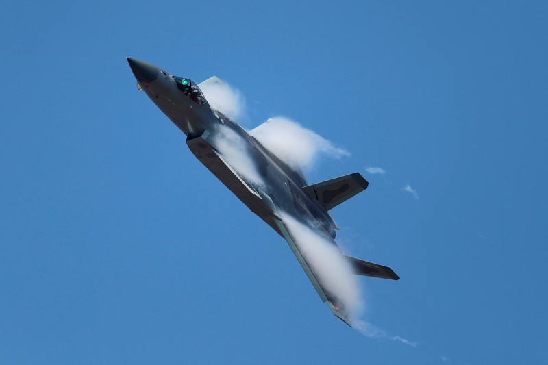Jet tempur siluman J-20 Angkatan Udara Tentara Pembebasan Rakyat China Pengunjung berkumpul untuk mengambil gambar jet tempur siluman J-20 selama Pameran Penerbangan dan Antariksa Internasional China ke-14 di Zhuhai di provinsi Guangdong, China selatan, Selasa (8/11/202). China menampilkan generasi jet tempur terbarunya. (Lu Hanxin/Xinhua via AP)