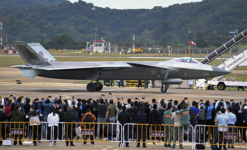 Jet tempur siluman J-20 Angkatan Udara Tentara Pembebasan Rakyat China Pengunjung berkumpul untuk mengambil gambar jet tempur siluman J-20 selama Pameran Penerbangan dan Antariksa Internasional China ke-14 di Zhuhai di provinsi Guangdong, China selatan, Selasa (8/11/202). China menampilkan generasi jet tempur terbarunya. (Lu Hanxin/Xinhua via AP)