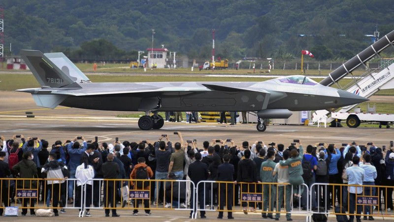 Pengunjung berkumpul untuk mengambil gambar jet tempur siluman J-20 selama Pameran Penerbangan dan Antariksa Internasional China ke-14 di Zhuhai di provinsi Guangdong, China selatan, Selasa (8/11/202). China menampilkan generasi jet tempur terbarunya. (Lu Hanxin/Xinhua via AP)